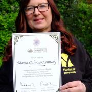 Maria Calway-Kennedy with her certificate signed  by King Charles and Queen Camilla