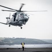 Undated handout photo issued by the Ministry of Defence of a Merlin helicopter conducting training with HMS Queen Elizabeth while anchored just off Plymouth Sound. This image won the Royal Navy Amateur Maritime Image Award, taken by AB Bill Spurr, in the