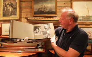 Antiques dealer Charles Wallrock of Wick Antiques with the photo album of Britannia's world tour in 1959. Picture: Wick Antiques/Deep South