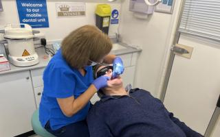 Dentist Mary Green treats a patient on the mobile dental unit