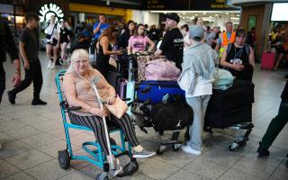 Elaine Bevan, 70, from Southampton, waits in the South Terminal at Gatwick Airport in Crawley, east Sussex, as widespread IT outages affecting airlines, broadcasters and banks, have caused long queues.