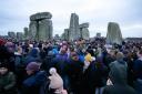 People take part in the winter solstice celebrations during sunrise at the Stonehenge prehistoric monument on Salisbury Plain in Wiltshire.