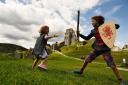 Children playing with toy swords at Corfe Castle, Dorset