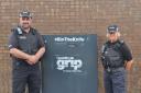 Police officers in front of knife bin