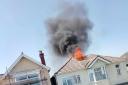 Flames erupt through roof of house during fire