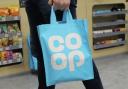 A shopper carrying a Co-op bag. Credit: PA