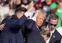 Donald Trump is helped off the stage by US Secret Service agents