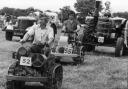 Parade of the vintage tractors at Netley Marsh Steam Rally lead by Mr. Ivan Moody driving a Ransome smallholder's tractor on 21st July 1979