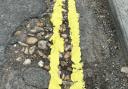 Council workers have come under fire after painting double yellow lines through the centre of potholes