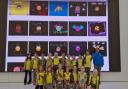 The Brownie pack in front of the large screen at the Apple store showcasing their emoji designs