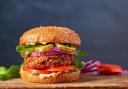 Homemade plant based burger made from sweet potato, black beans and brown rice on a whole wheat brioche bun; copy space