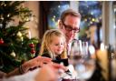 Father and daughter sharing a joyful moment during Christmas dinner.