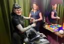 MP Caroline Nokes looks on as Verity Wall cuts a client's hair in her safe space salon in Romsey