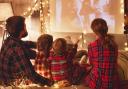 A family watching a movie wearing pyjamas