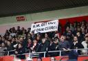 Fans hold Russell Martin out sign during the match against Spurs