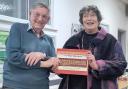 Doug Glading presenting the Victory in Europe commemorative book to Penny Melville-Brown at the historic Catisfield memorial hall