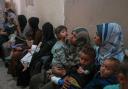 Palestinian women wait with their sick children for medical care in an overcrowded clinic in Gaza City (Jehand Alshrafi/AP)