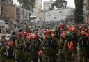 Rescue workers inspect the site where an Iranian missile struck in Bnei Brak, near Tel Aviv (Leo Correa/AP)