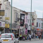 A wanted man who was “acting suspiciously” in a high street was apprehended by police