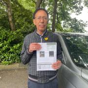 Jon Windeatt, 87, holding a previous Parking Charge Notice (PCN).