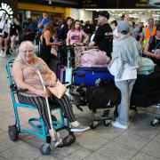 Elaine Bevan, 70, from Southampton, waits in the South Terminal at Gatwick Airport in Crawley, east Sussex, as widespread IT outages affecting airlines, broadcasters and banks, have caused long queues.