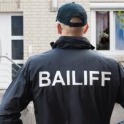 A bailiff enforcing a repossession.