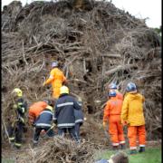 Dog stuck in bonfire pile at Swanmore. Firefighters and the Search and Rescue team look for Milo as owner George Smith junior waits.