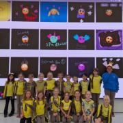 The Brownie pack in front of the large screen at the Apple store showcasing their emoji designs