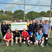 Cheque presentation to Hampshire and Isle of Wight Air Ambulance at a recent walking football session at Eastleigh’s Silverlake stadium.