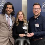 Professor Subodh Dave, College Dean presenting the award to Katy Bartolomeo, operational lead for Older People’s Mental Health and Marc Ashley-Mann, programme manager