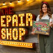 Rachel Lowe MBE holding the Destination The Repair Shop board-game