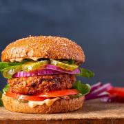 Homemade plant based burger made from sweet potato, black beans and brown rice on a whole wheat brioche bun; copy space