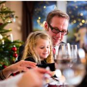 Father and daughter sharing a joyful moment during Christmas dinner.