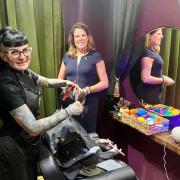 MP Caroline Nokes looks on as Verity Wall cuts a client's hair in her safe space salon in Romsey