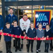 ParalympicsGB Athlete: Aaron Phipps. with Dan Jollie Store Manager and children from Calmore infants