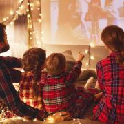 A family watching a movie wearing pyjamas