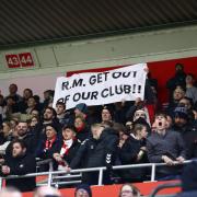 Fans hold Russell Martin out sign during the match against Spurs