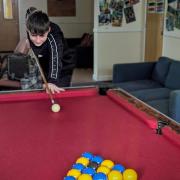 A student at The Polygon School playing pool