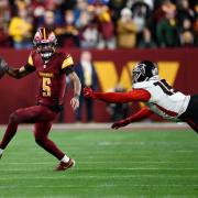 Washington Commanders quarterback Jayden Daniels scrambles away from Atlanta Falcons offensive tackle Brandon Parker (Nick Wass/AP)