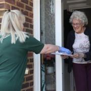A HILS team member delivers a hot meal and a friendly check-in