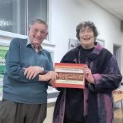 Doug Glading presenting the Victory in Europe commemorative book to Penny Melville-Brown at the historic Catisfield memorial hall
