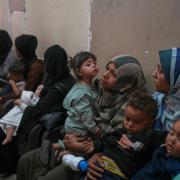 Palestinian women wait with their sick children for medical care in an overcrowded clinic in Gaza City (Jehand Alshrafi/AP)