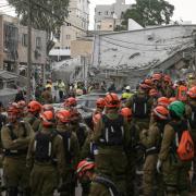 Rescue workers inspect the site where an Iranian missile struck in Bnei Brak, near Tel Aviv (Leo Correa/AP)