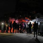 Palestinians line up to buy dinner at a food stand near the beachfront in Gaza City (AP Photo/Jehad Alshrafi/AP)