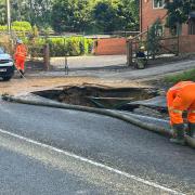 Southern Water workers at the sinkhole, hours after a man rode his bicycle over the hole and fell in.