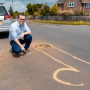 Cllr Jack Davies, member of New Forest District Council, next to the member drawn around the pothole