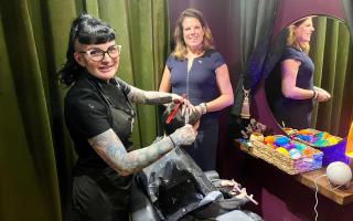 MP Caroline Nokes looks on as Verity Wall cuts a client's hair in her safe space salon in Romsey