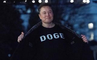 FILE – Elon Musk flashes his T-shirt that reads “Doge” to the media as he walks on the South Lawn of the White House in March (Jose Luis Magana/AP, File)