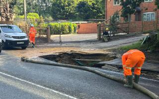 Southern Water workers at the sinkhole, hours after a man rode his bicycle over the hole and fell in.
